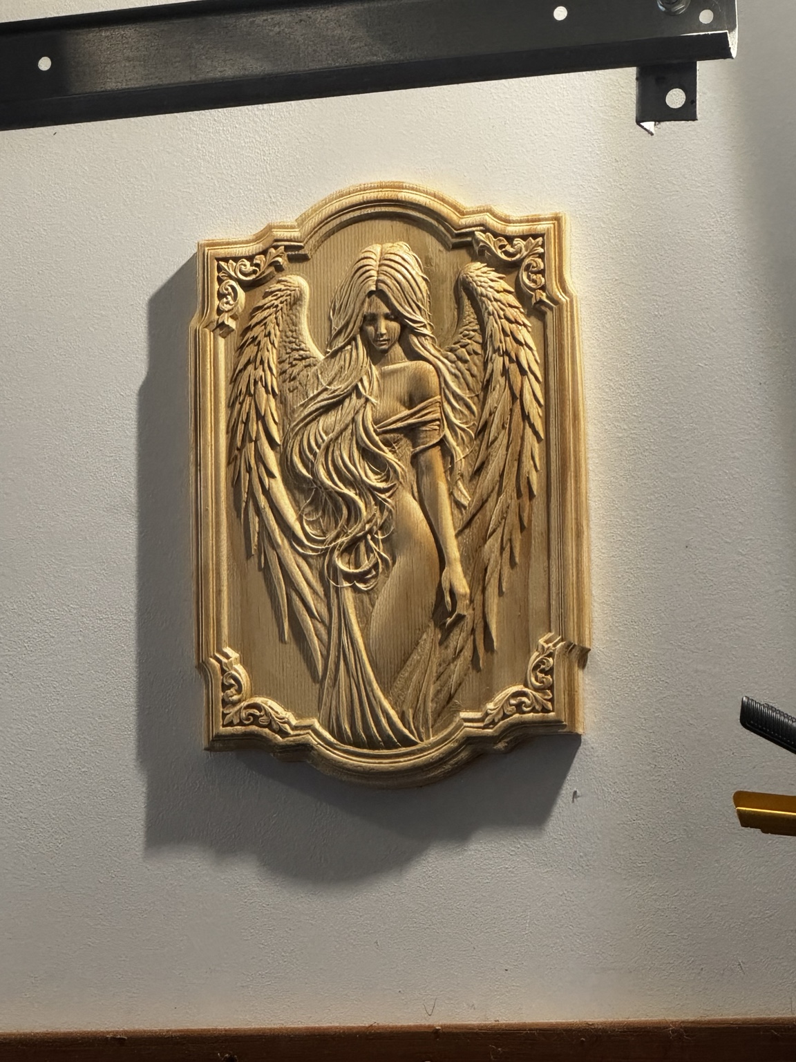 Detailed angel with flowing hair and feathered wings carved in wood