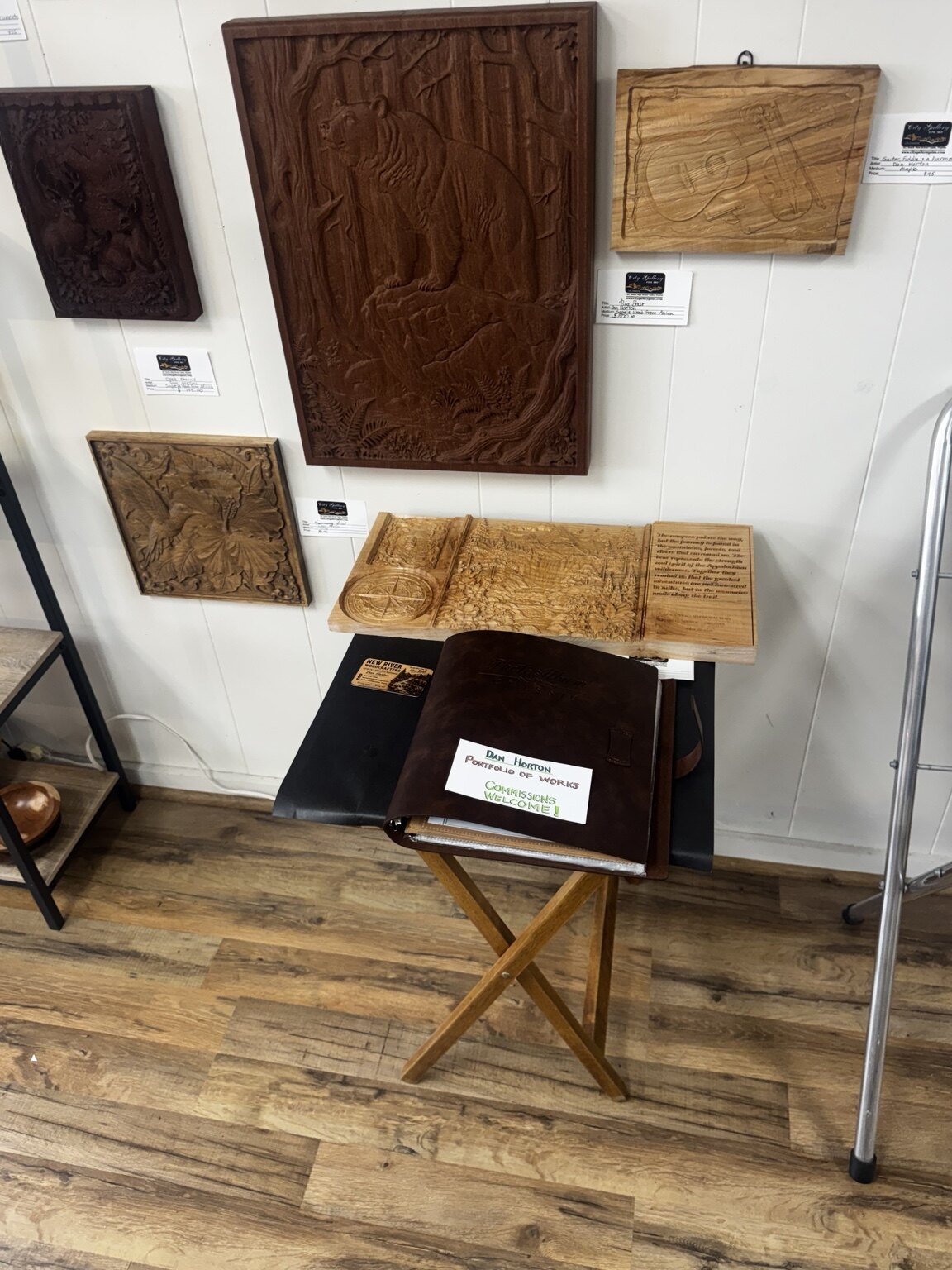 Current New River Woodcrafters display at City Gallery with bear, deer, hummingbird, and music relief carvings
