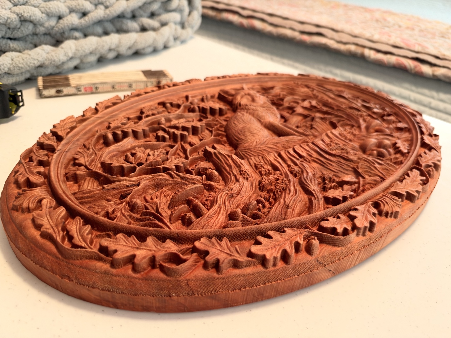 Angled view showing the depth and oak-leaf border of the cherry fox carving