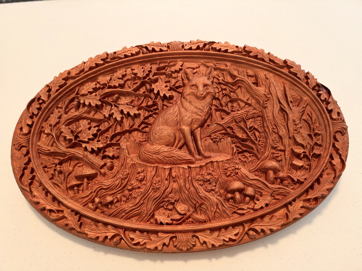 Oval cherry relief of a fox on a tree stump, surrounded by oak leaves, woodland mushrooms, and an ornate carved border
