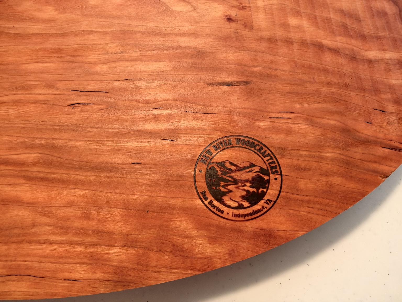 Close-up of the New River Woodcrafters maker’s mark on the cherry carving