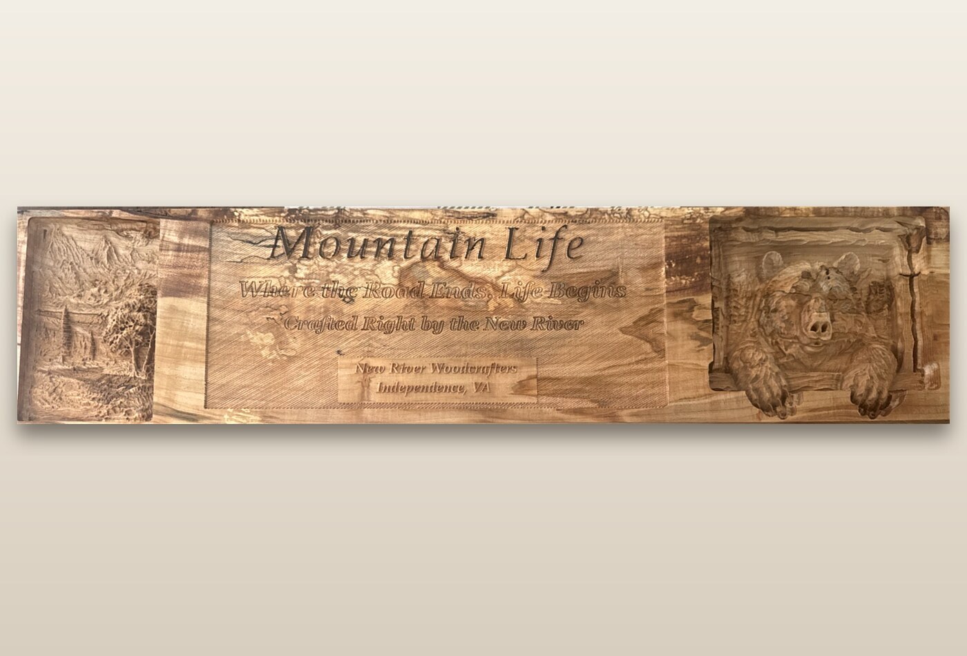 Wide Mountain Life sign with a waterfall scene and bear relief